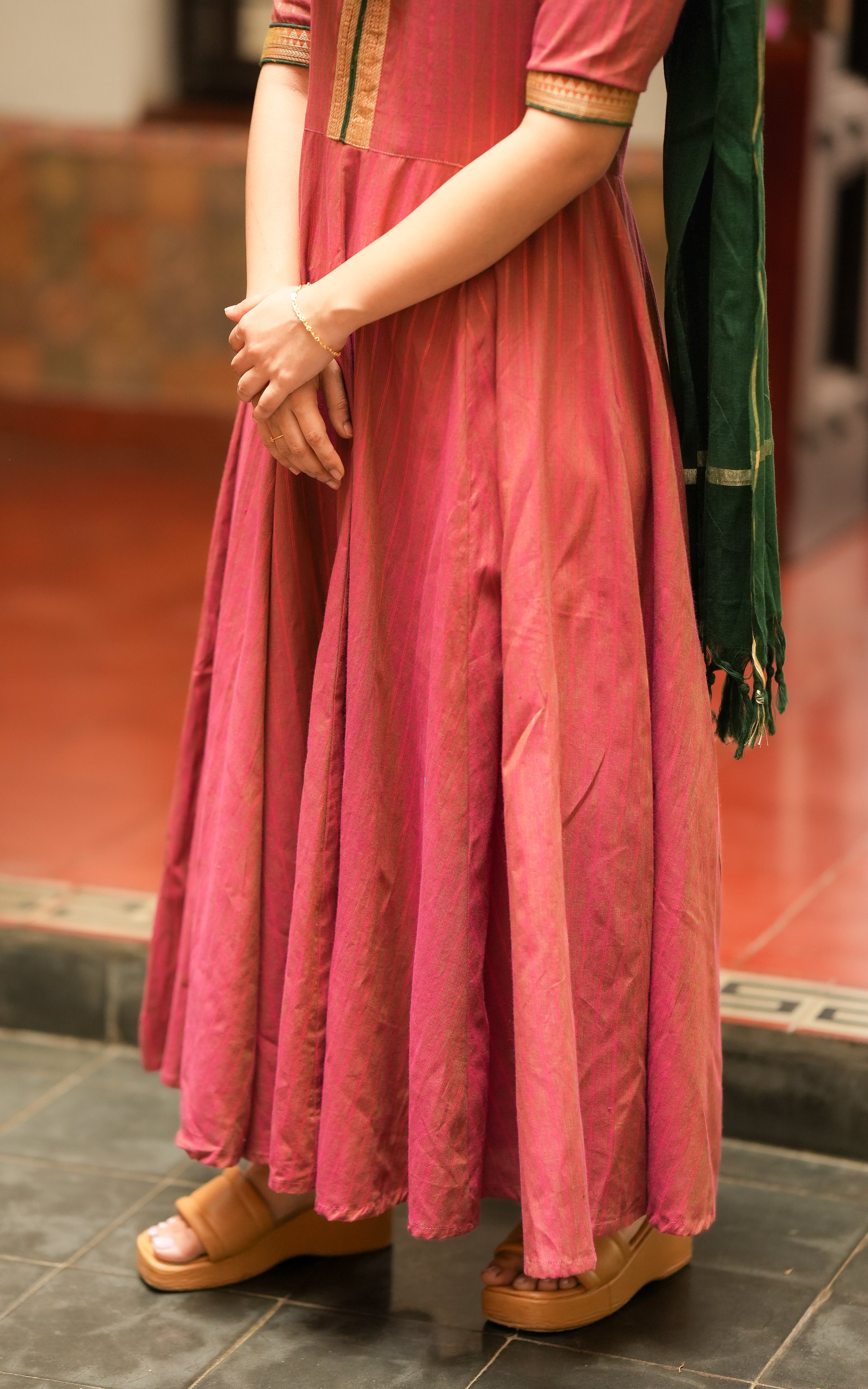 A dark green dupatta with gold border is draped over the shoulders, replicating the color combination from Annapoorani.