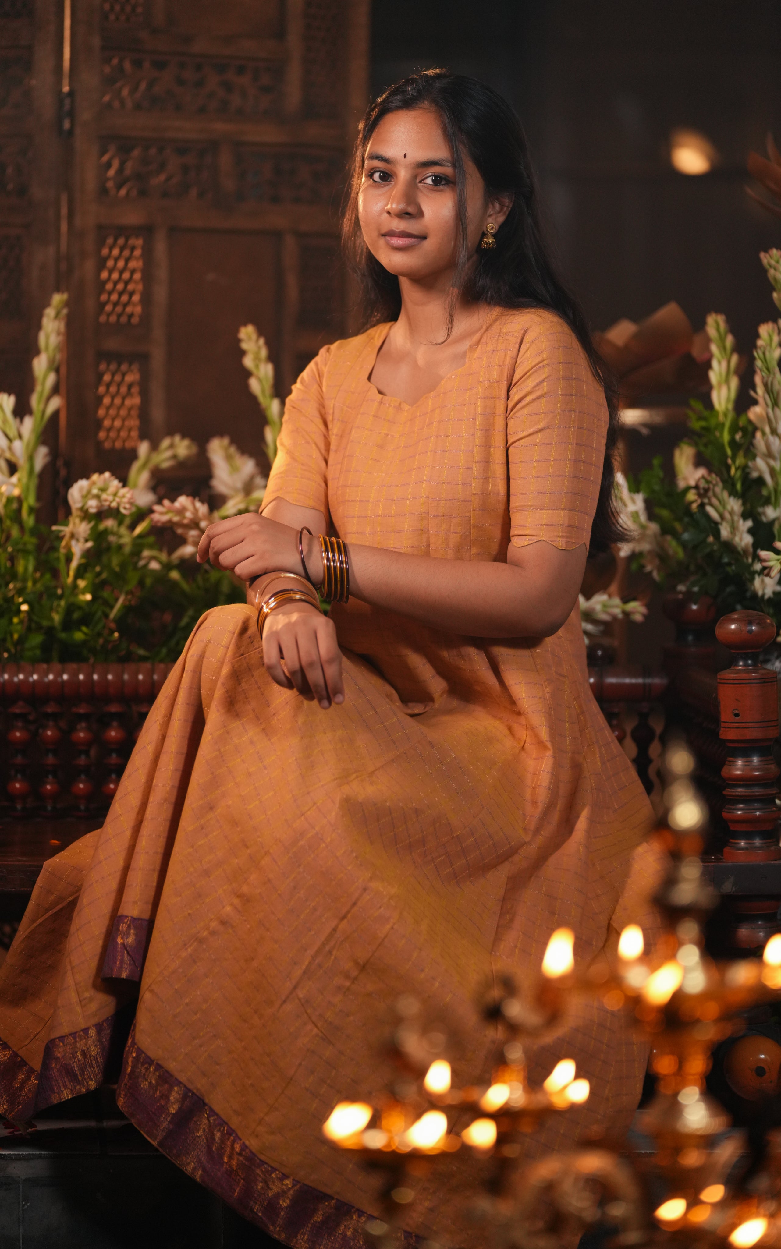 Woman wearing a mustard yellow Anarkali dress made of textured fabric.