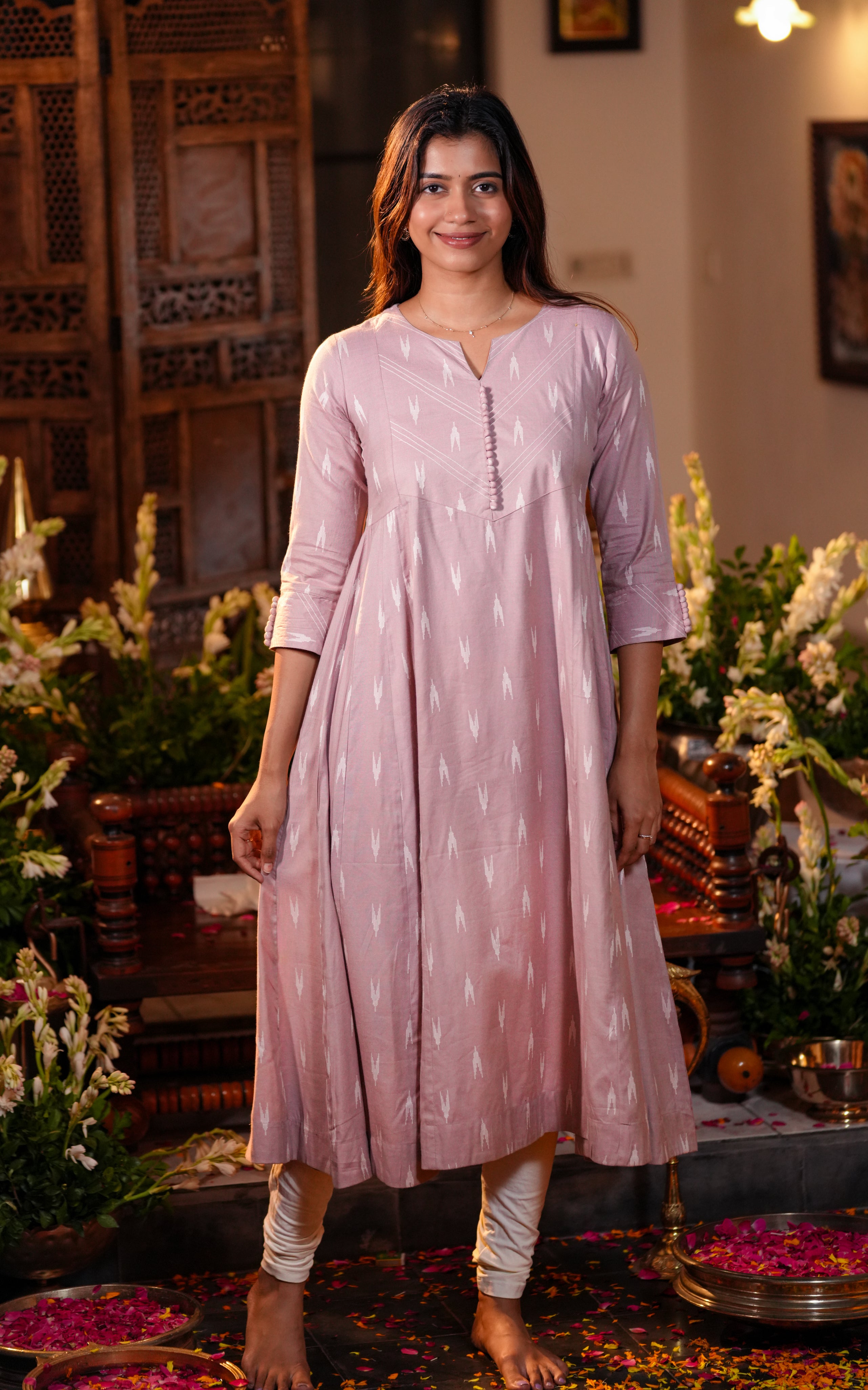 A woman is wearing a soft light pink Anarkali kurti made from blended viscose fabric.