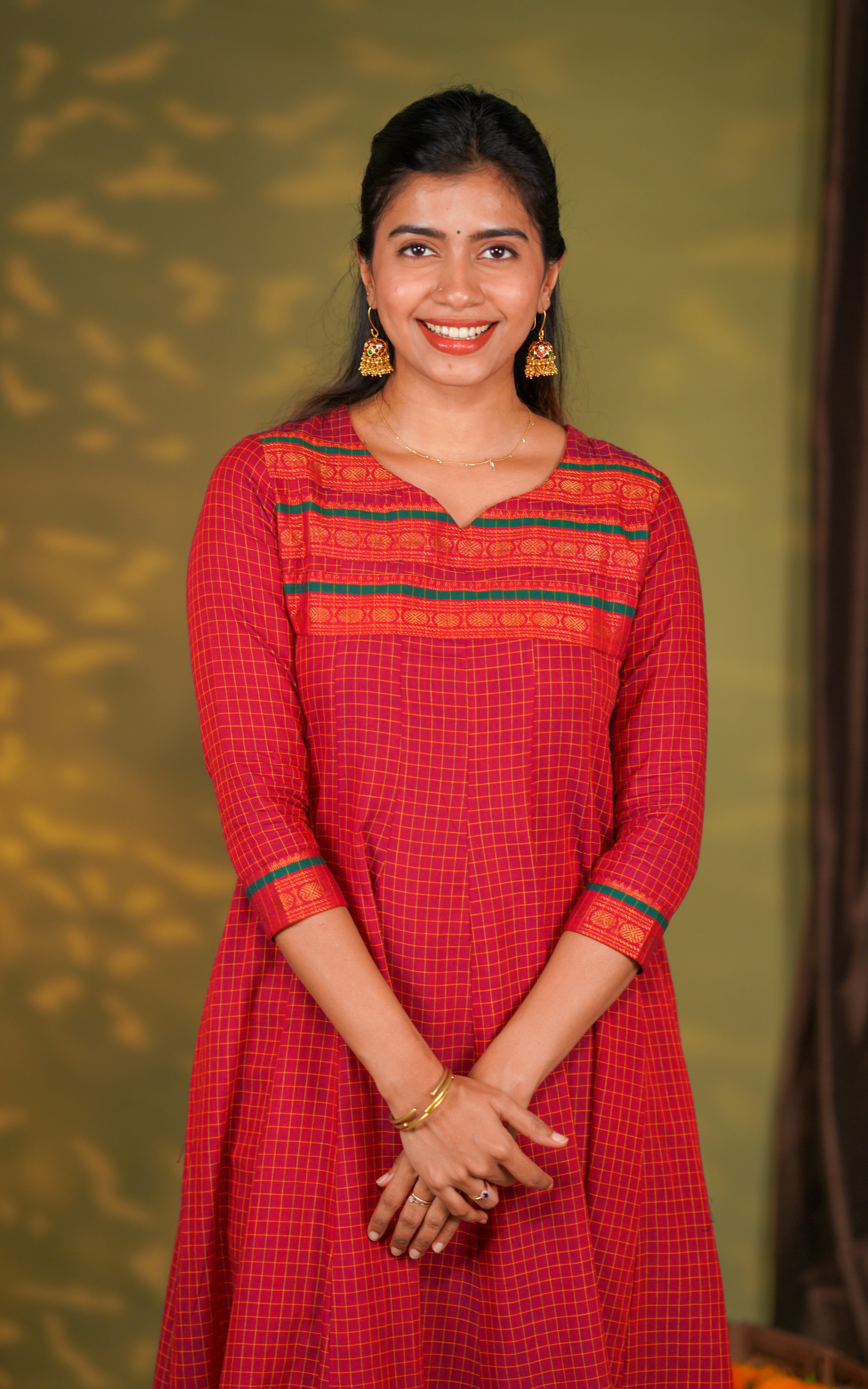 checked cotton Anarkali dress designed with a premium soft-touch fabric. The neckline features a stylish contrast red and orange patterned yoke