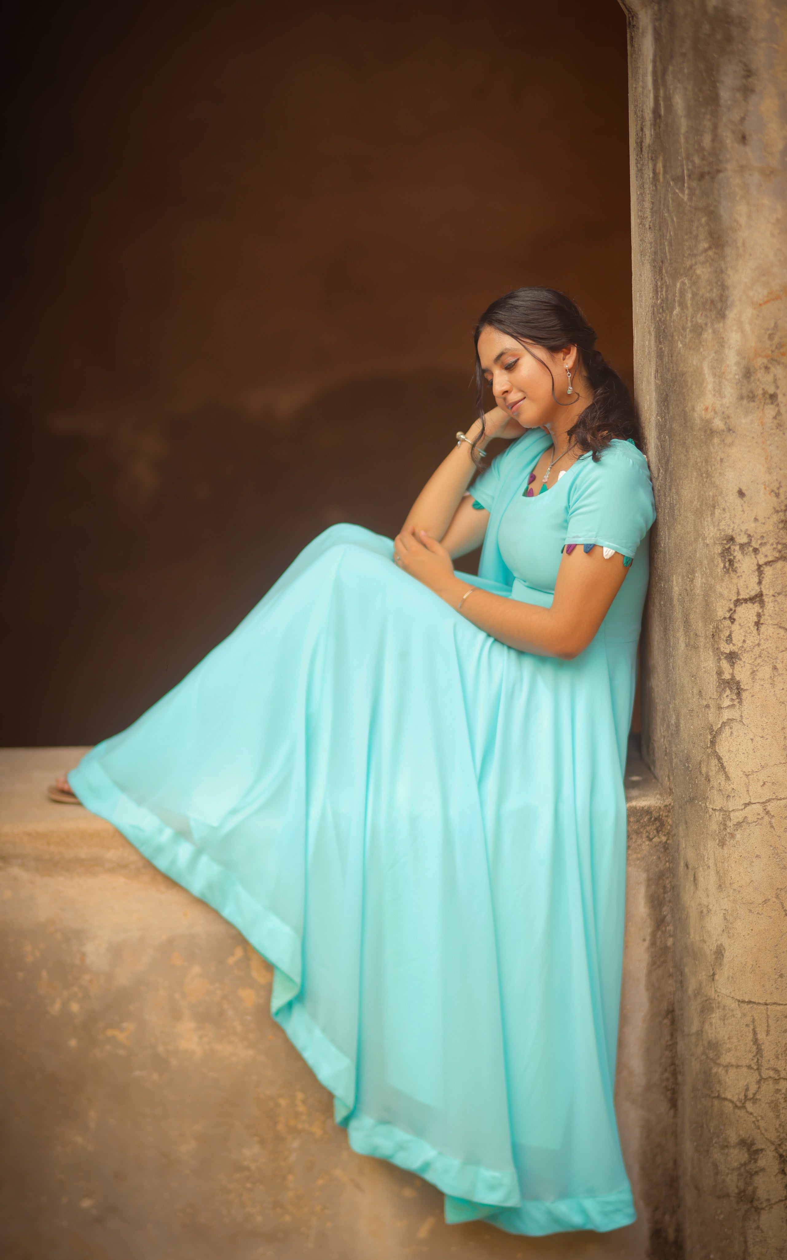 A woman wearing a sky blue full flared anarkali dress with dupatta