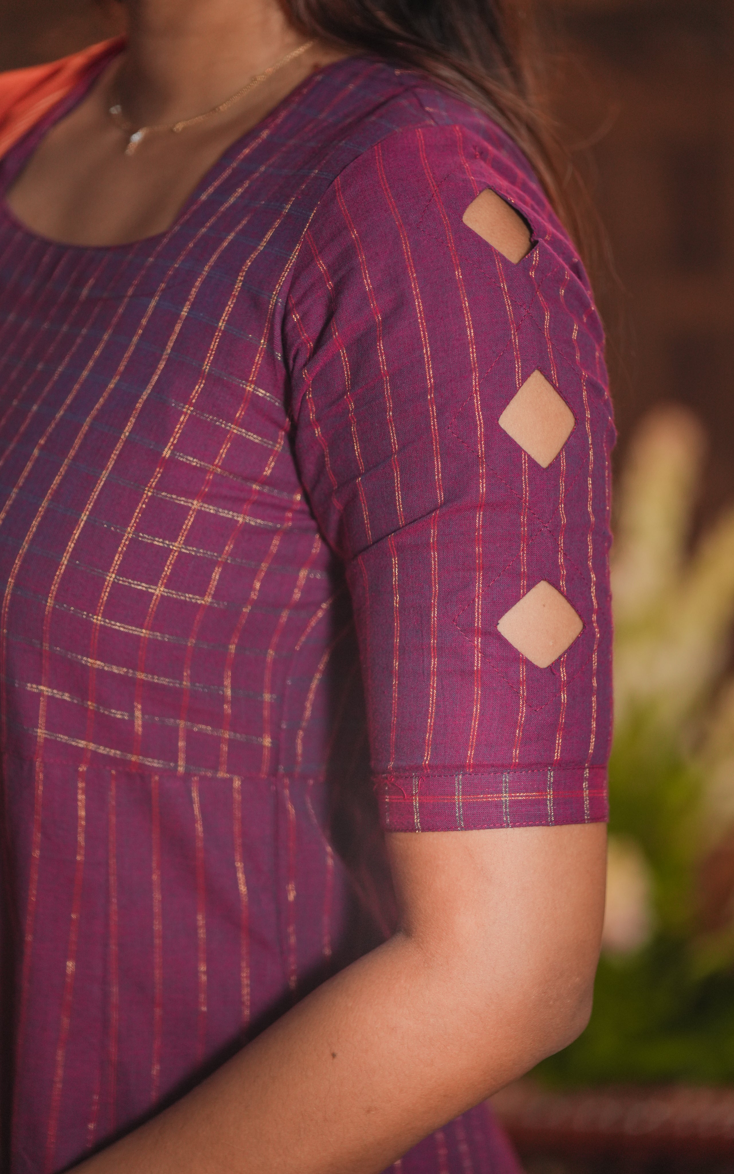 The cutwork on sleeves adds a playful and stylish element to the classic silhouette.