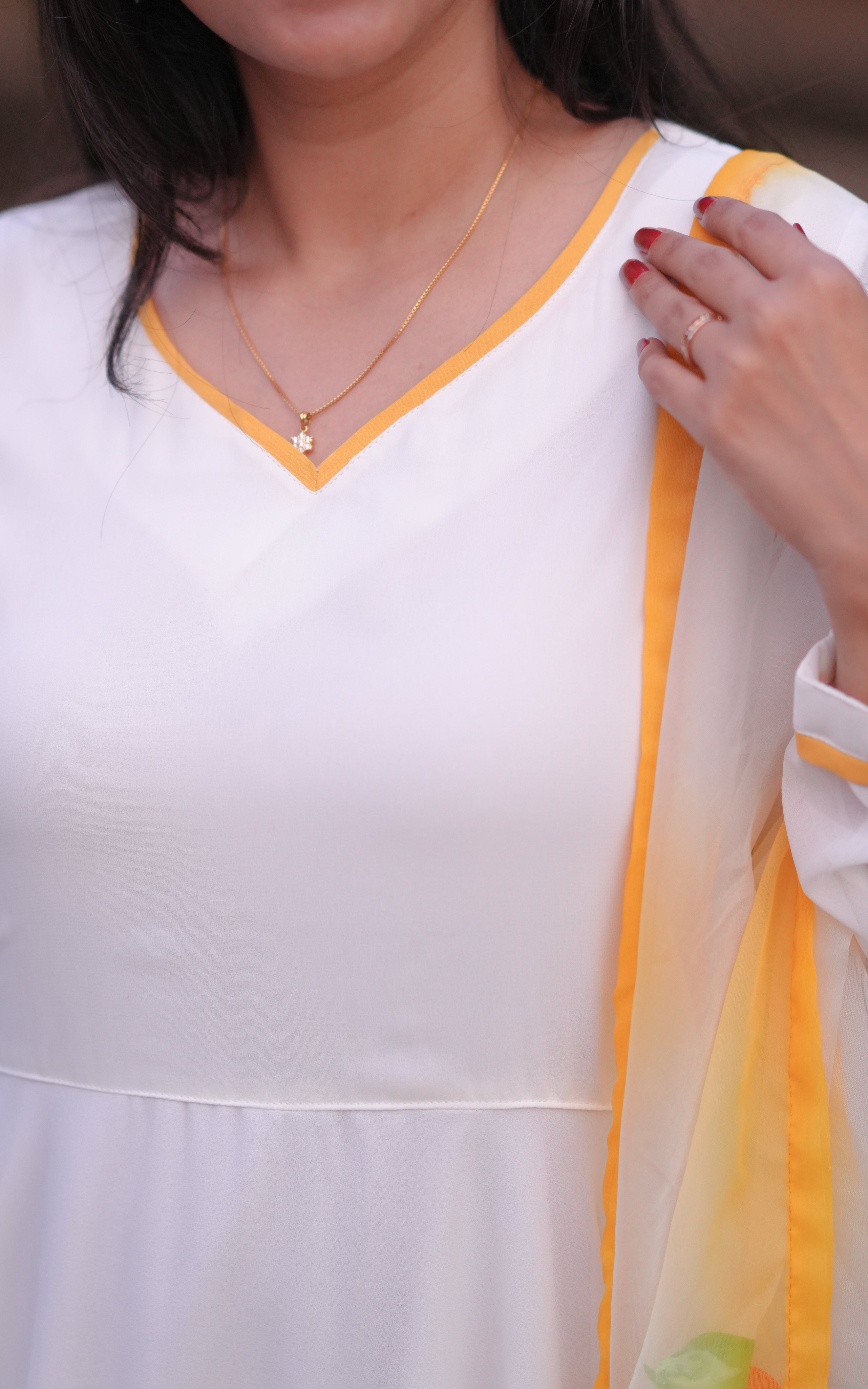 Features a V-neck with a subtle yellow border for an elegant touch.