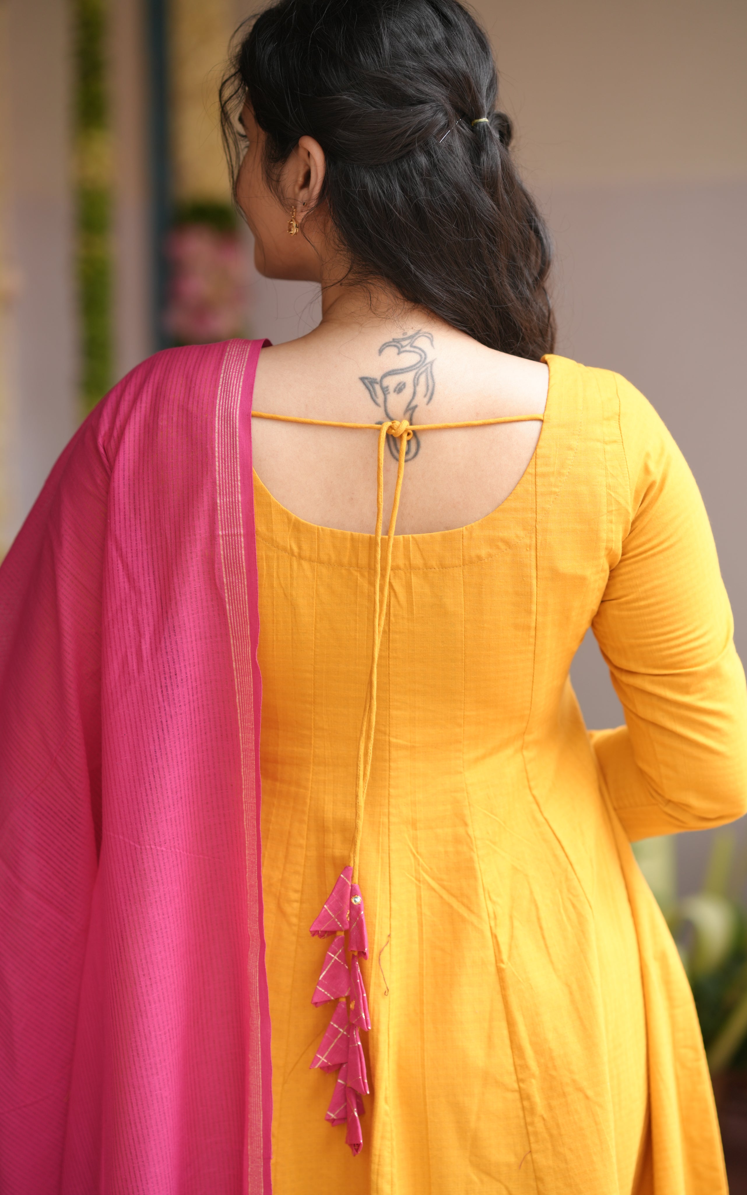 Woman wearing a yellow outfit with pink dupatta